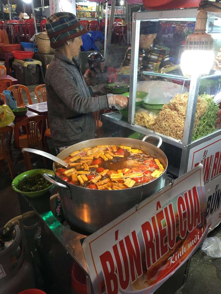 A typical street food stall. This woman has only one dish to offer – the sign says it all!