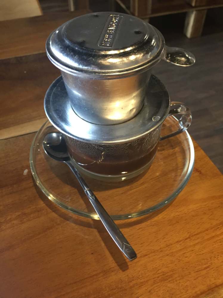 Waiting for a glass of coffee to drip through the phin.